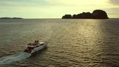เรือคาตามารันยามพระอาทิตย์ตกข้างเกาะเล็ก ๆ
